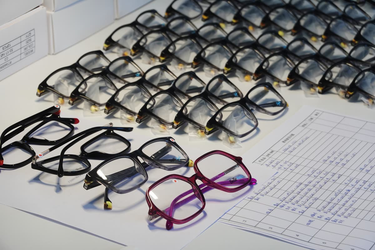 Rows of inspected frames on a bench, a handful pulled aside, next to a handwritten defect log